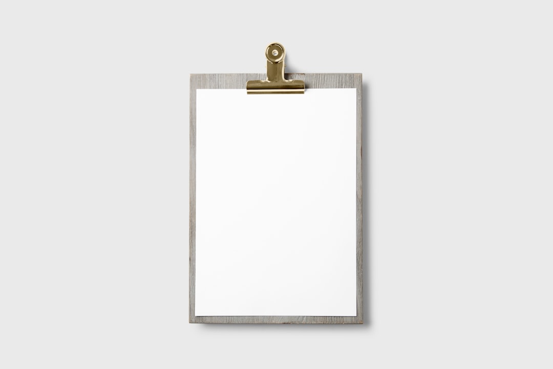 Empty clipboard with a wooden frame set against a plain gray background